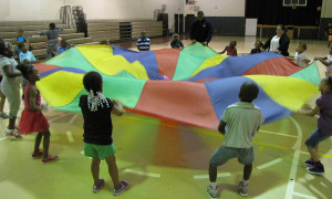 Students filled their summer vacation with educational activities, arts and crafts, weekly field trips and sports such as swimming at New Community’s Summer Camp, which is organized by the Youth Services Department. Above, students played with a parachute during the first day of camp held at the New Community Neighborhood Center on Hayes Street.
