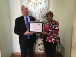 Dr. Nicholas Guittari, Extended Care medical director, and Veronica Onwunaka, administrator at Extended Care and director of Health and Social Services for New Community, show off the plaque designating Guittari as a Top Doctor for 2017.