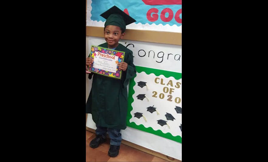 HHELC Graduation 2020 Boy Showing Off Certificate Black Background