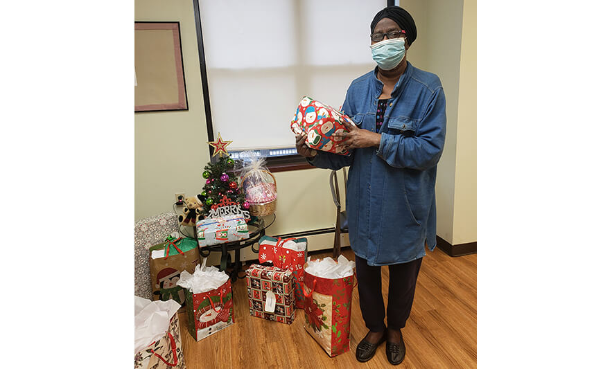 Manor Senior Christmas Presents Woman Holding Snowman Gift for Website