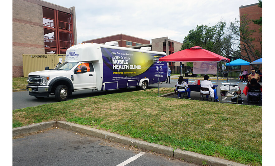 Extended Care Health Fair 7-29-2022 Essex County Mobile Health Clinic van and back of tables for web